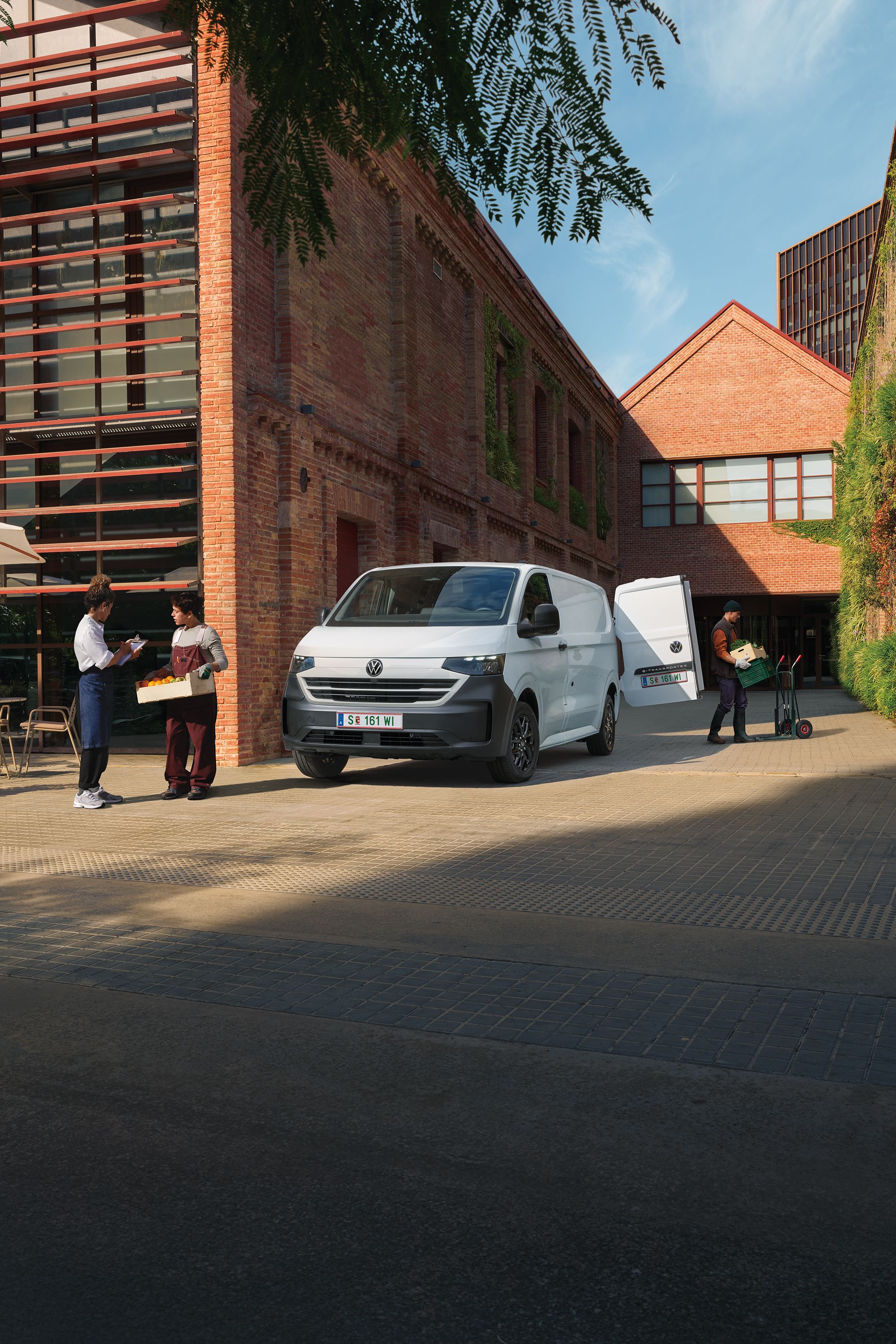 VW Transporter Kastenwagen in Weiß steht vor Haus