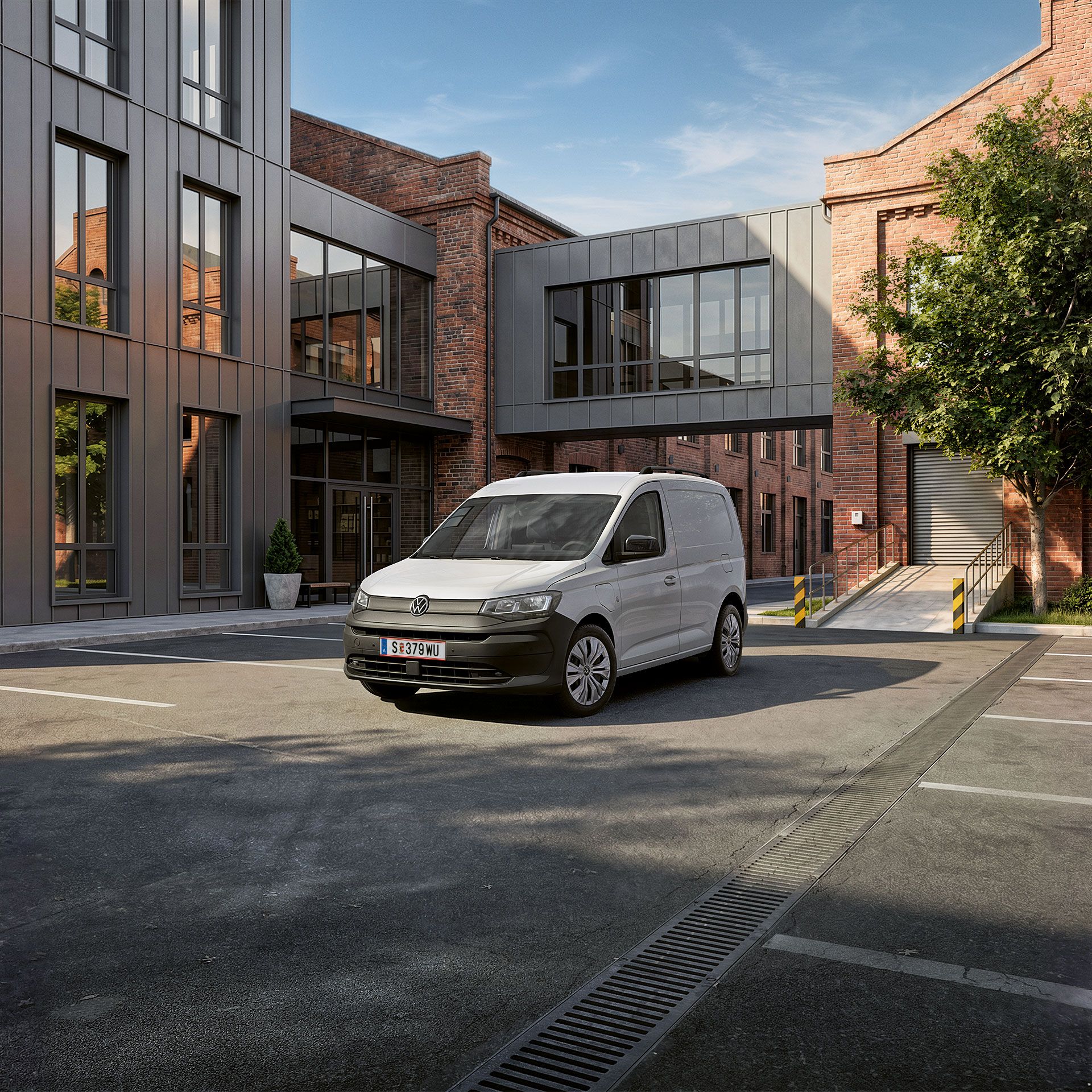 Der neue Caddy Cargo in Weiß steht vor Gebäude.