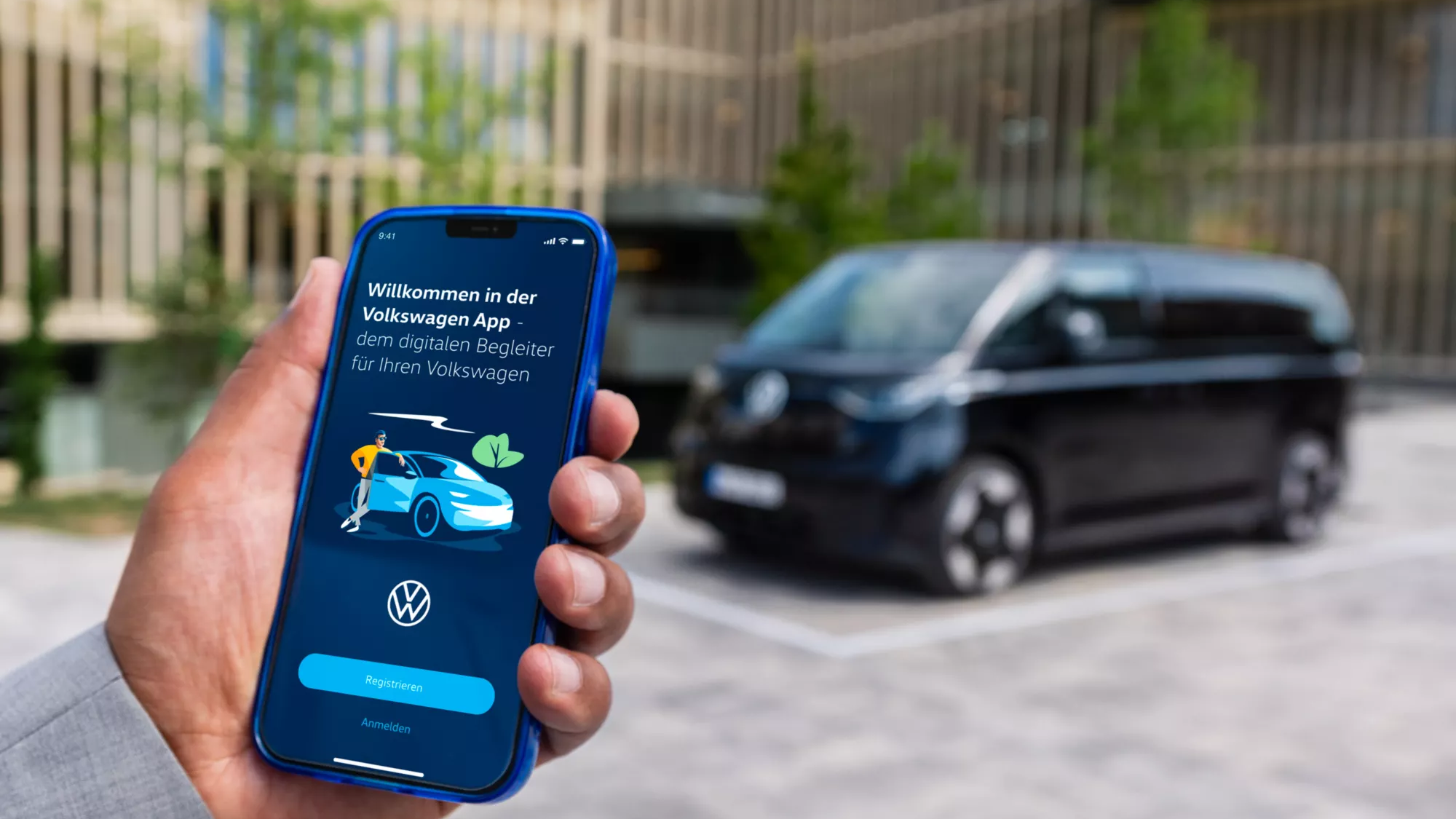 Mann meldet sich bei der Volkswagen App an, schwarzer ID. Buzz im Hintergrund